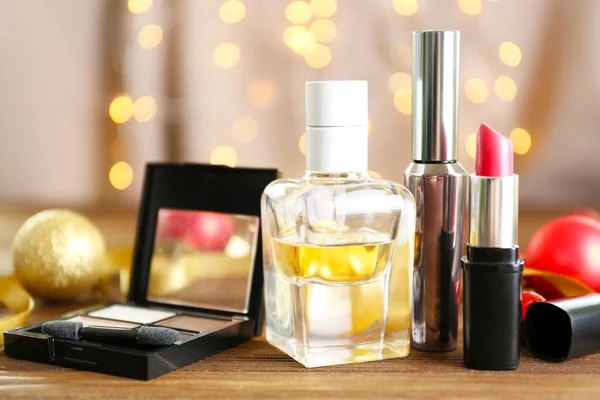 Kosmetik makeup berwarna dengan dekorasi Natal di atas meja kayu — Stok Foto
