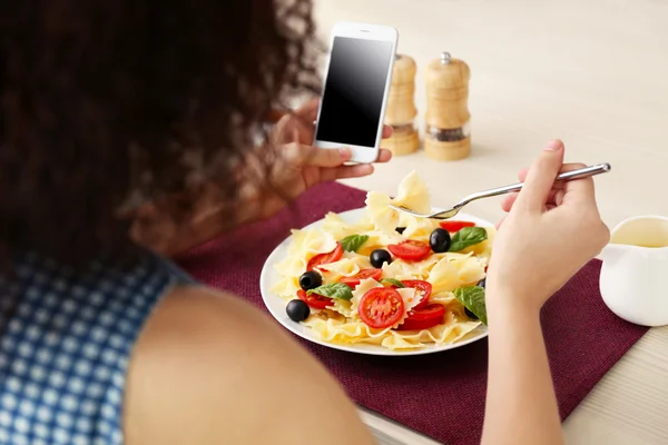 Woman eating delicious pasta in restaurant — Stock Photo, Image