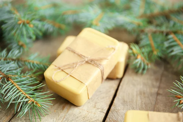 Pièces de savon résineux et branches sur fond bois, vue rapprochée — Photo