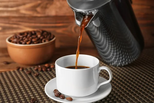 Свіжа кава, що ллється з горщика в чашку — стокове фото