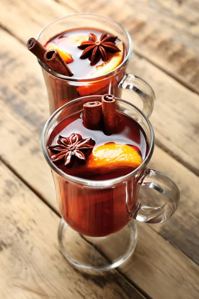 Heerlijk kerst kopjes glas glühwein op houten achtergrond, close-up — Stockfoto