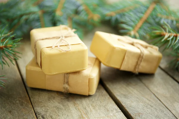 Pieces of coniferous soap and branches on wooden background, close up view — Stock Photo, Image