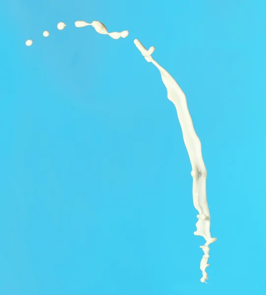 青の背景に牛乳のスプラッシュ — ストック写真
