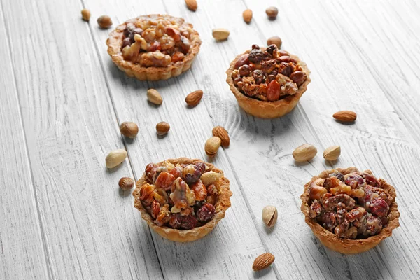 Delicious nut cakes on wooden table