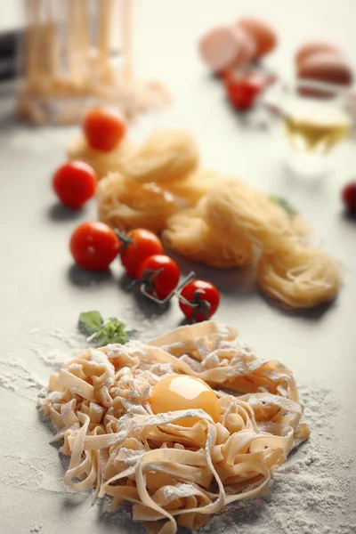 Dry pasta and some products on kitchen table — Stock Photo, Image