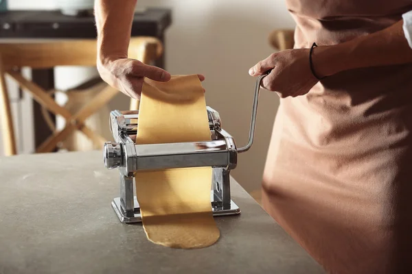 Man using pasta machine to prepare dough for tagliatelle, close up view — Stock Photo, Image