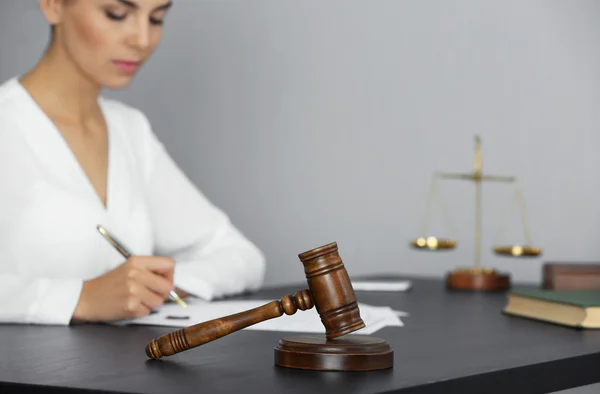 Rechter hamer en zakenvrouw zittend aan tafel — Stockfoto