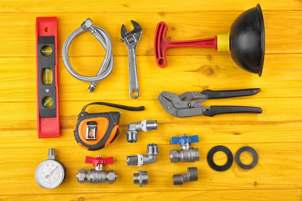 Plumber tools on yellow wooden background — Stock Photo, Image