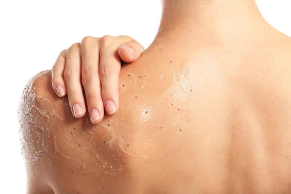 Mujer joven aplicando exfoliante en hombro sobre fondo blanco —  Fotos de Stock