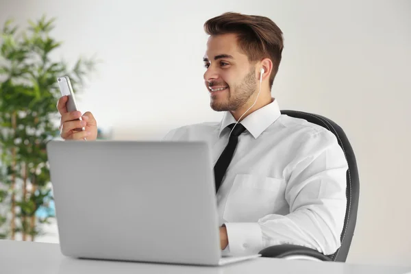 Handsome young man using cellphone at office — Stock Photo, Image