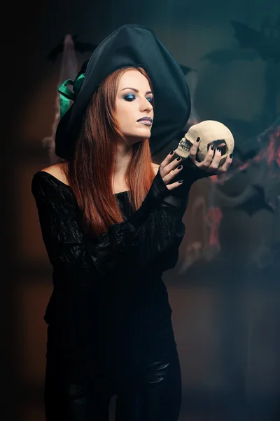 Young woman dressed in witch costume for Halloween, on dark background — Stock Photo, Image