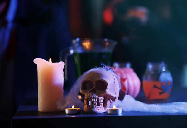 Человеческий череп, паутина и свеча на размытом фоне, закрываются. Концепция Хэллоуина — стоковое фото