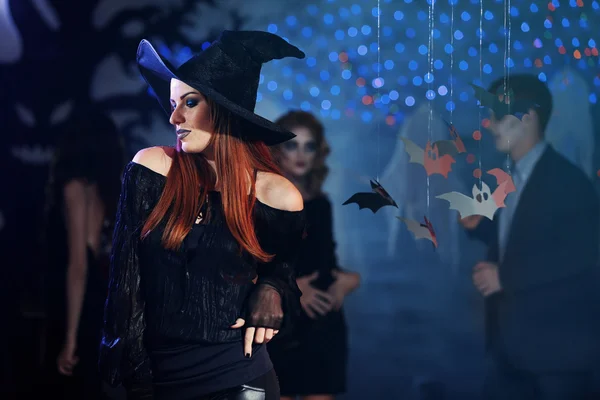 Молодая женщина в костюме ведьмы на Хэллоуинской вечеринке — стоковое фото