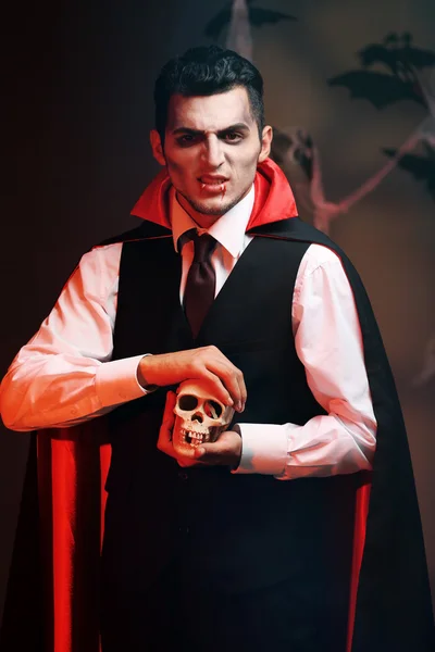 Young man dressed as vampire for Halloween party, on dark background — Stock Photo, Image