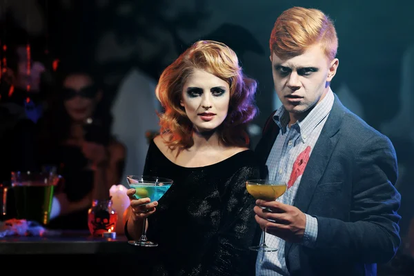 Young people in costumes drinking cocktails at Halloween party — Stock Photo, Image