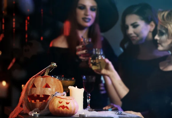 Pessoas em trajes perto da mesa com decoração de Halloween — Fotografia de Stock