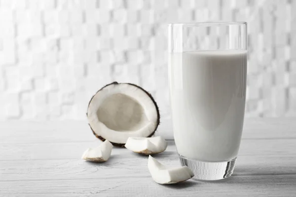 Copo de leite de coco saboroso em mesa de madeira contra fundo branco desfocado — Fotografia de Stock