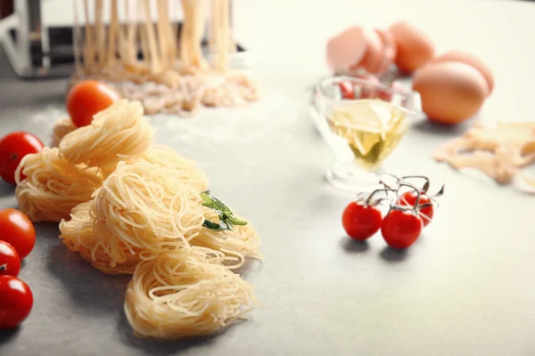 Pastas secas, tomates y albahaca en la mesa de la cocina —  Fotos de Stock