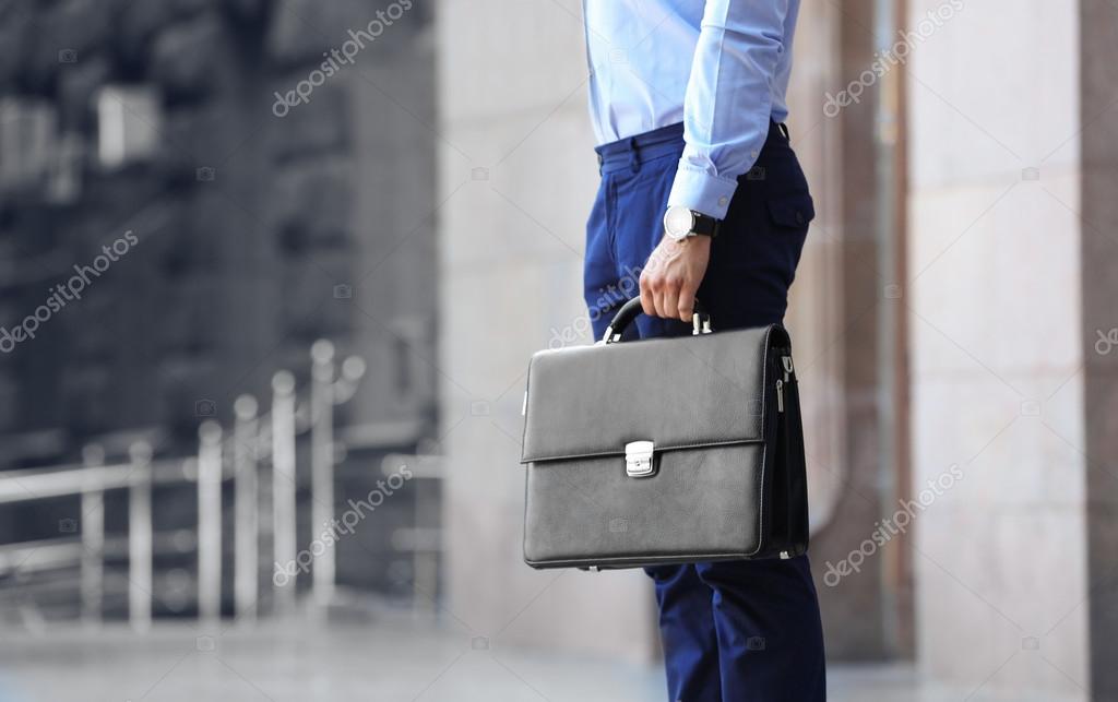 Lawyer holding briefcase on the street Stock Photo by ©belchonock 127220588