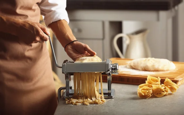 Człowiek za pomocą maszyny makaron przygotować makaron tagliatelle, zbliżenie — Zdjęcie stockowe