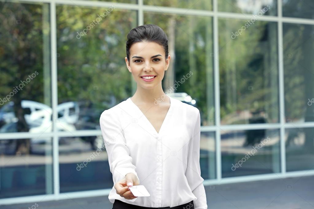 Businesswoman giving business card on window background