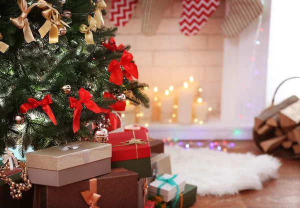 Bela árvore de Natal e caixas com presentes no fundo borrado — Fotografia de Stock