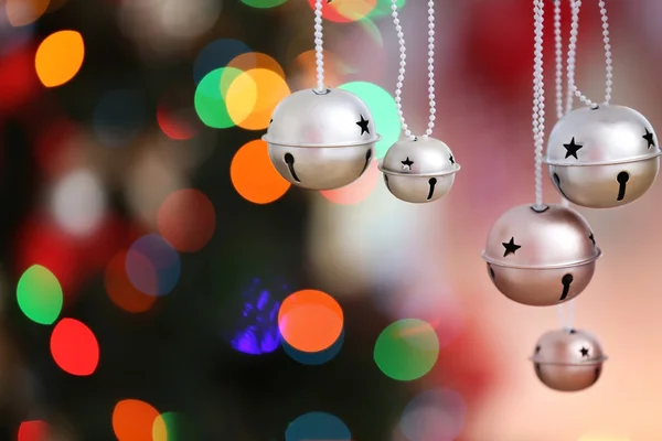 Sinos jingle em luzes de Natal borradas fundo, close-up — Fotografia de Stock