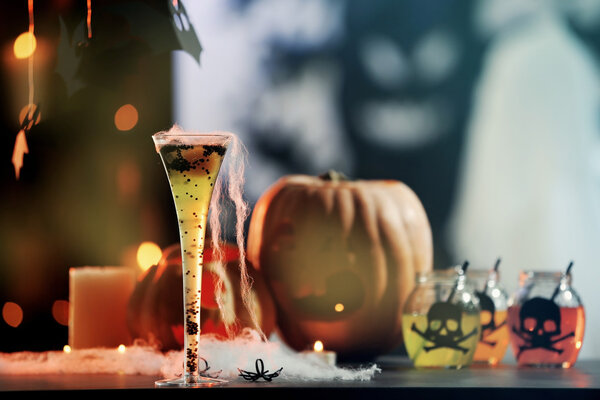 Tasty cocktail with decor for Halloween, on blurred background