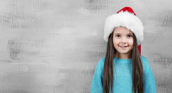 산타 모자를 쓰고 있는 귀여운 소녀 색 배경 사진 — 스톡 사진