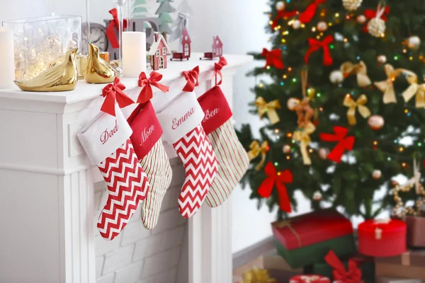 Christmas socks hanging on fireplace in room interior — Stock Photo, Image