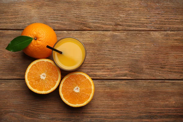 Naranjas con jugo sobre mesa de madera — Foto de Stock