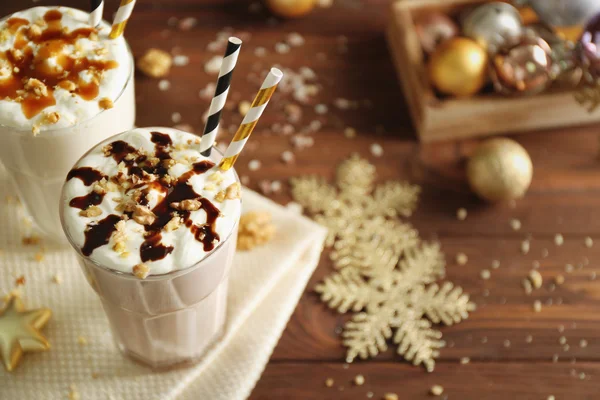 Läcker milkshake med juldekoration på träbord närbild — Stockfoto