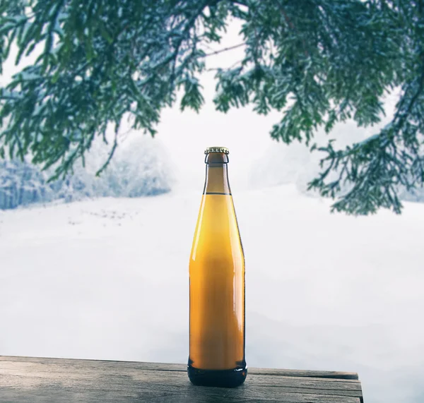 A sör a téli természet háttér fából készült asztal üveg. — Stock Fotó