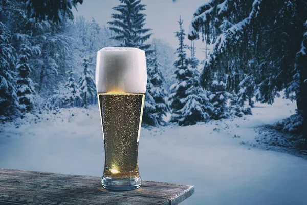 Copo de cerveja na mesa de madeira contra fundo natureza inverno . — Fotografia de Stock
