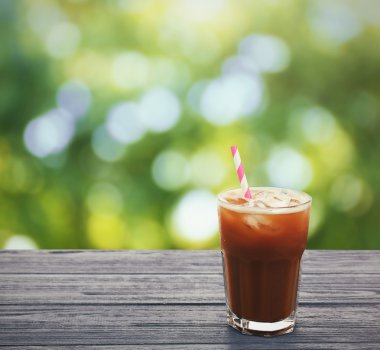 Cam soğuk kahve bulanık doğa arka plan karşı ahşap tablo