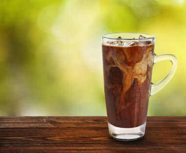 Cam soğuk kahve bulanık doğa arka plan karşı ahşap tablo