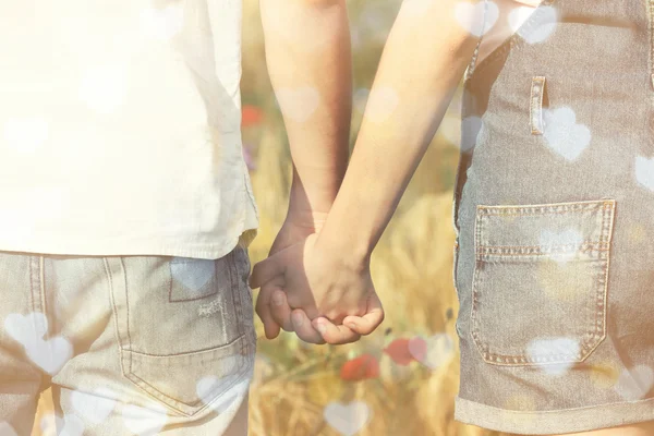 Giovane coppia che tiene le mani insieme su sfondo campo sfocato — Foto Stock