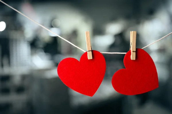 Two red hearts hanging on rope against blurred background. — Stock Photo, Image