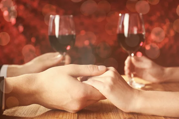 Young couple holding hands together at restaurant — Stock Photo, Image