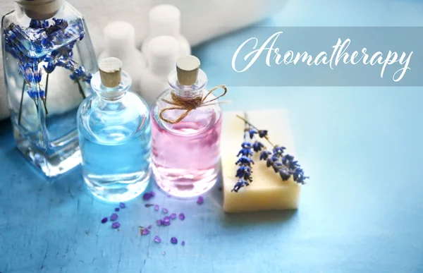 Spa composition with essential oils and lavender, closeup. Word AROMATHERAPY on background. Spa beauty concept. — Stock Photo, Image