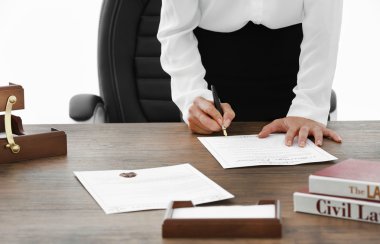 Female lawyer signing documents in office, close up view clipart