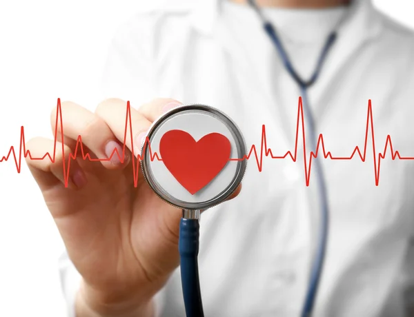 Electrocardiogram, red heart and female hand with stathoscope, closeup. Cardiology concept. — Stock Photo, Image