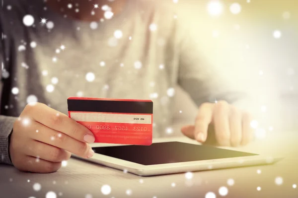 Female hands with credit card and tablet, closeup. Snowy effect, online Christmas shopping concept. — Stock Photo, Image