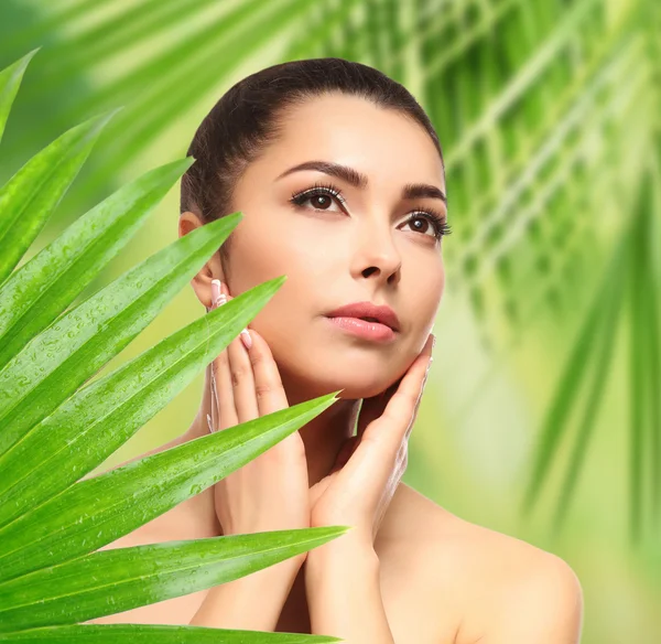 Beautiful young woman and green foliage, closeup. — Stock Photo, Image