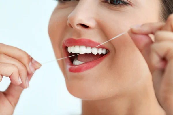 Jeune femme nettoyer les dents avec de la soie dentaire, gros plan — Photo