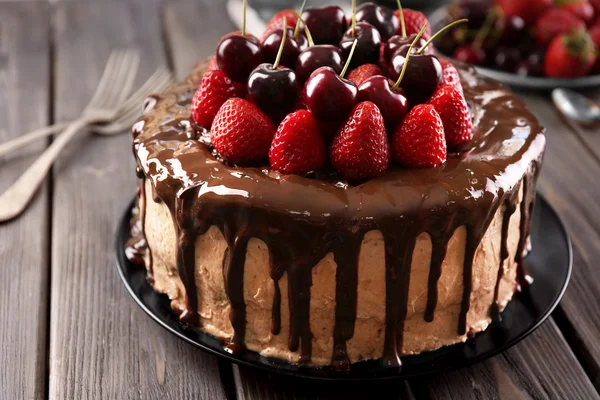 Delicioso pastel con cereza y fresa en la mesa —  Fotos de Stock