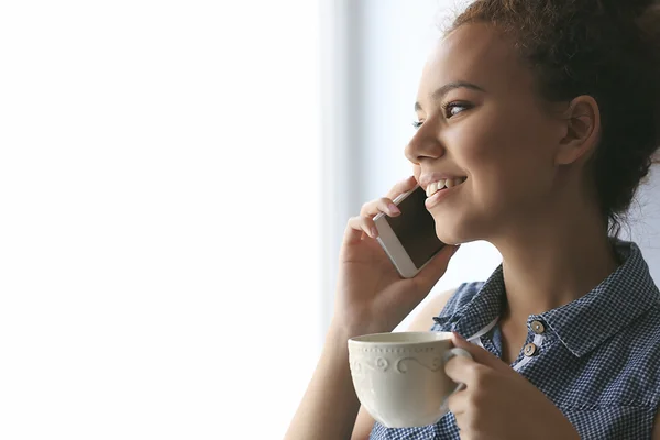 Ritratto di bella ragazza afroamericana con caffè e cellulare — Foto Stock