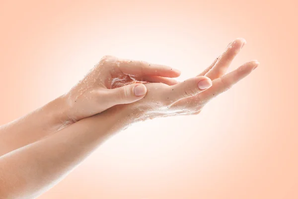Vrouwelijke handen met scrub op kleur achtergrond. Huid zorg concept. — Stockfoto