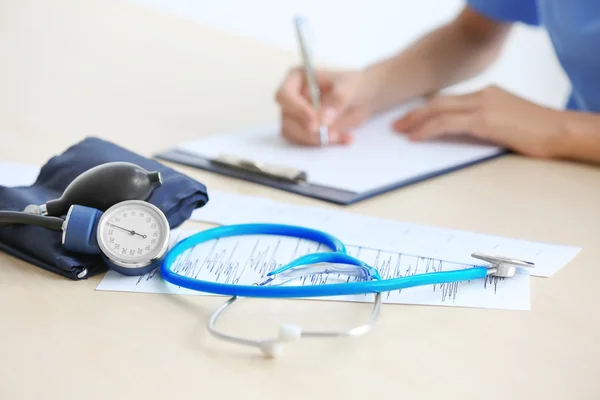 Estetoscopio y medidor de presión arterial en la mesa del médico — Foto de Stock