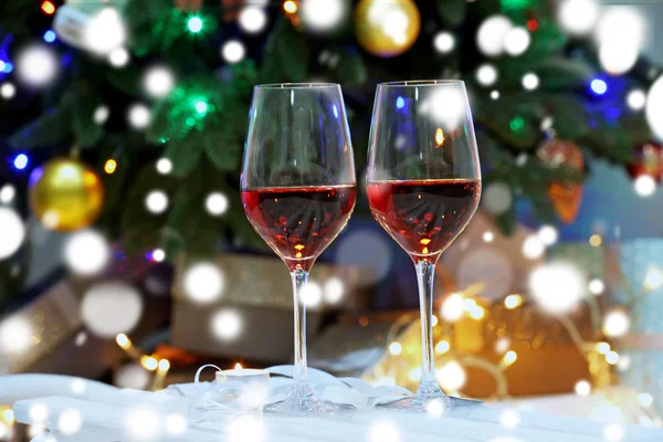Glas rött vin på suddig jul interiör bakgrund. Christmas celebration koncept. — Stockfoto